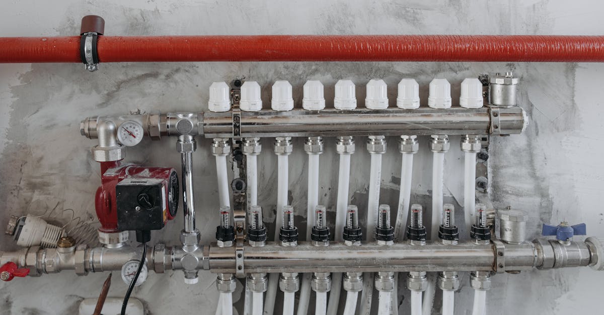 a close up view of an industrial manifold with pressure gauges and connected steel pipes